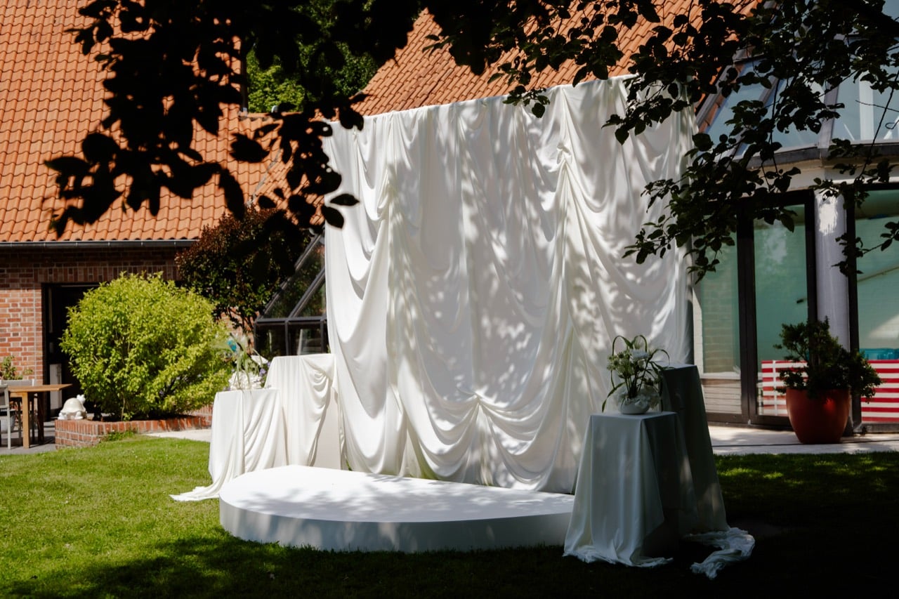 Décor de cérémonie de mariage avec fond drapé blanc