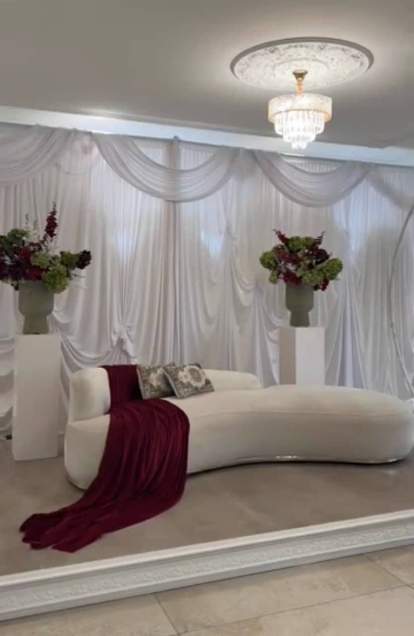 Décor professionnel avec fond drapé et canapé blanc